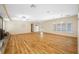 Open-concept living room featuring hardwood floors, ample space, and natural light from large windows at 401 Whitcomb Blvd, Tarpon Springs, FL 34689
