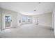 A bright living room featuring neutral carpeting, new paint, and large windows that offer a beautiful view at 401 Whitcomb Blvd, Tarpon Springs, FL 34689