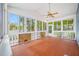 Spacious screened porch with wood floors, white trim, large windows and views of the lush landscaping at 401 Whitcomb Blvd, Tarpon Springs, FL 34689
