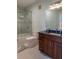 Well-lit bathroom with granite counters, wood cabinets, and a glass-enclosed shower at 4221 W Spruce St # 1303, Tampa, FL 33607