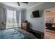 Bedroom featuring a large window, wood dresser, and mounted TV at 4221 W Spruce St # 1303, Tampa, FL 33607