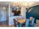 Elegant dining area with modern lighting, a wooden table, and stylish chairs set against a blue accent wall at 4221 W Spruce St # 1303, Tampa, FL 33607