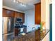 Well-equipped kitchen with stainless steel appliances, dark wood cabinets, and a granite countertop bar at 4221 W Spruce St # 1303, Tampa, FL 33607