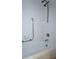 A bathtub with white tiling and shower head and safety bar at 4345 Tahitian Gardens Cir # C, Holiday, FL 34691