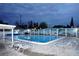 Community pool with clear blue water, surrounded by lounge chairs and palm tree murals on the fence at 4345 Tahitian Gardens Cir # C, Holiday, FL 34691