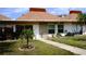 Charming single-story condo featuring a well-maintained lawn and covered front porch at 4345 Tahitian Gardens Cir # C, Holiday, FL 34691