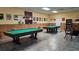 Spacious game room with two pool tables, paneled walls, and game decor for resident entertainment at 4345 Tahitian Gardens Cir # C, Holiday, FL 34691