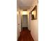 Well-lit hallway with wood flooring, a mirror, and multiple doors at 4345 Tahitian Gardens Cir # C, Holiday, FL 34691