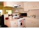 Efficient kitchen space with clean white cabinetry, basic appliances, and a view to the dining area at 4345 Tahitian Gardens Cir # C, Holiday, FL 34691