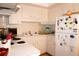 Functional kitchen featuring white cabinets, essential appliances, and a clean, organized layout at 4345 Tahitian Gardens Cir # C, Holiday, FL 34691
