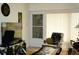 Comfortable living area with a cozy armchair, a television, and natural light from the screened doorway at 4345 Tahitian Gardens Cir # C, Holiday, FL 34691