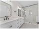 Modern bathroom featuring double vanity, marble countertops, and glass-enclosed shower at 4911 N Nebraska Ave, Tampa, FL 33603