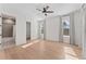 Bright bedroom with light wood floors, ceiling fan, two windows, and bathroom view at 4911 N Nebraska Ave, Tampa, FL 33603