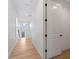 Bright hallway with light wood flooring and white walls, leading to other rooms at 4911 N Nebraska Ave, Tampa, FL 33603