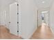 Well-lit hallway with light hardwood floors and white trim at 4911 N Nebraska Ave, Tampa, FL 33603