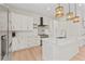 Contemporary kitchen featuring white cabinets, stainless steel appliances, island, and decorative backsplash at 4911 N Nebraska Ave, Tampa, FL 33603
