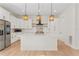 Sleek kitchen featuring white cabinets, stainless steel appliances, a central island, and pendant lighting at 4911 N Nebraska Ave, Tampa, FL 33603