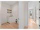 Bright laundry room with wood floors, floating shelves, white cabinets, and sink at 4911 N Nebraska Ave, Tampa, FL 33603