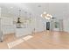 A bright open-concept living space with hardwood floors, modern lighting fixtures, and a kitchen island at 4911 N Nebraska Ave, Tampa, FL 33603