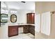 Bathroom with dark wood cabinets, granite countertops, and vanity mirror with lighting at 5112 Lanai Way, Tampa, FL 33624
