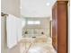 Bathroom featuring a large soaking tub with travertine surround and a glass shower at 5112 Lanai Way, Tampa, FL 33624