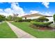 The side of a one-story home featuring lush green lawns, manicured landscaping and mature trees at 5112 Lanai Way, Tampa, FL 33624