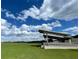 Rolling green space with a partially enclosed shelter or pavilion under a beautiful cloudy sky at 5112 Lanai Way, Tampa, FL 33624