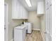 Functional laundry room with modern appliances, storage cabinets, and wood-look floors at 5112 Lanai Way, Tampa, FL 33624