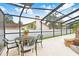 Screened-in patio with wrought iron table and chairs next to a custom rock waterfall feature at 5112 Lanai Way, Tampa, FL 33624
