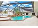 Enclosed pool with a custom rock waterfall feature, mature landscaping, and easy access to the home at 5112 Lanai Way, Tampa, FL 33624