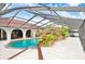 Spacious screened-in pool featuring custom rock waterfall, mature landscaping, and an arched covered patio at 5112 Lanai Way, Tampa, FL 33624