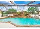 Enclosed pool with a custom rock waterfall feature, mature landscaping, and ample patio space at 5112 Lanai Way, Tampa, FL 33624