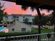 Balcony view captures a vibrant sunset over a lush landscape and community pool at 531 Sandy Hook Rd, Treasure Island, FL 33706