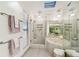 Modern bathroom features a glass shower, jacuzzi tub, pendant lighting, and tiled floors at 531 Sandy Hook Rd, Treasure Island, FL 33706