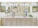 Well-lit bathroom with double sink vanity, decorative mirrors, and ample storage space at 531 Sandy Hook Rd, Treasure Island, FL 33706