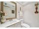 Elegant half-bathroom with white vanity, decorative mirror, and textured walls at 531 Sandy Hook Rd, Treasure Island, FL 33706