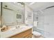Bright bathroom featuring a shower, tile floor, sink, and a decorative mirror at 531 Sandy Hook Rd, Treasure Island, FL 33706