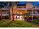 Rear exterior view of multi-story condo building with balconies and a well manicured lawn at 531 Sandy Hook Rd, Treasure Island, FL 33706