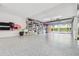 Well-lit garage featuring epoxy floors, storage shelves, and an open garage door at 531 Sandy Hook Rd, Treasure Island, FL 33706