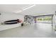 Spacious garage with epoxy floors, shelving, and an open door to the exterior at 531 Sandy Hook Rd, Treasure Island, FL 33706