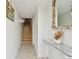 Inviting hallway featuring a staircase, seashell-decorated mirror, and stylish decor at 531 Sandy Hook Rd, Treasure Island, FL 33706
