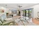 Open living room featuring a media center and sliding glass doors to the deck and pool area at 531 Sandy Hook Rd, Treasure Island, FL 33706
