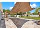 Backyard patio area with a sail shade, mature landscaping, and a white privacy fence at 5875 Darren N Ct, Clearwater, FL 33760