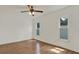 Bright bedroom features hardwood floors, ceiling fan, and two windows for natural light at 5875 Darren N Ct, Clearwater, FL 33760