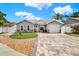 Charming single-story home with manicured lawn, stone accents, and a patterned brick driveway at 5875 Darren N Ct, Clearwater, FL 33760