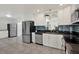 Bright kitchen featuring stainless steel appliances, white cabinets, and a blue backsplash at 5875 Darren N Ct, Clearwater, FL 33760