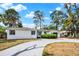 Classic single-story home with a gray driveway, minimalist landscaping, and a stylish blue door at 6120 5Th N Ave, St Petersburg, FL 33710
