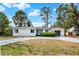 Beautiful single-story home with a gray driveway, lush landscaping, and a sleek gray garage door at 6120 5Th N Ave, St Petersburg, FL 33710