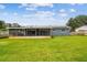 Beautiful view of the backyard and rear home elevation with screened porch at 6246 Bandura Ave, New Port Richey, FL 34653