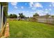Expansive fenced backyard with lush green grass and a charming fireplace at 6246 Bandura Ave, New Port Richey, FL 34653